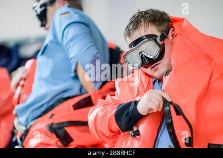 Neustadt, Deutschland. März 2020. Soldaten der Bundeswehr trainieren den Einbau von Rettungsanzügen im Einsatz-Ausbildungszentrum Schadenabwehr Marine (EAZSM). Jede U-Boot-Besatzung kann sich plötzlich in der prekären Situation befinden, das Boot in einer Tiefe von 30 Metern verlassen zu müssen. Was dann zu tun ist, lernen die Soldaten der Deutschen Marine in diesem Turm in Neustadt in Holstein. Kredit: Axel Heimken / dpa / Alamy Live News Stockfoto