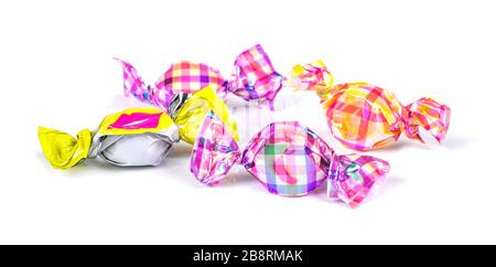 Bonbons in farbener Folie auf weißem Hintergrund eingewickelt Stockfoto