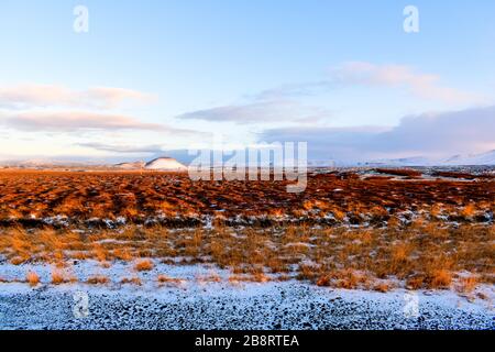 Ein Blick vom Straßenrand in Island mit herbstlichen Filten, die sich zum Horizont hin erstrecken Stockfoto