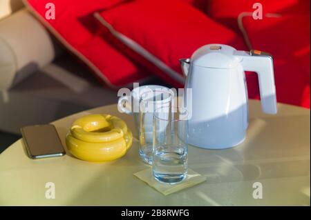 wasserkocher und Kaffee- oder Teebecher auf einem Balkontisch Stockfoto