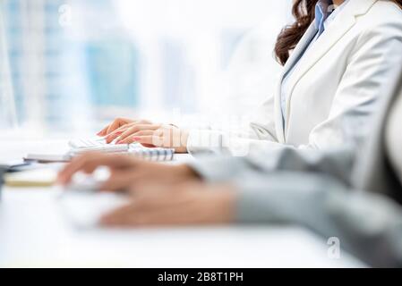 Hände von Frauen Angestellte mit weißem Kragen, die an Computertastaturen schreiben, die im Büro arbeiten Stockfoto