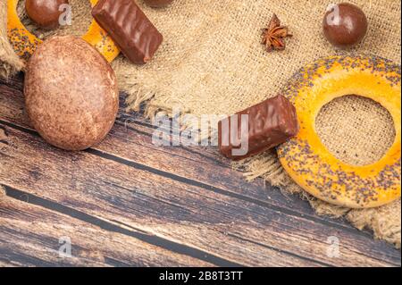 Bagels, Schokoladenkuchen, Schokolade und ein Stück grober Homespun-Qualität auf Holzgrund. Nahaufnahme Stockfoto