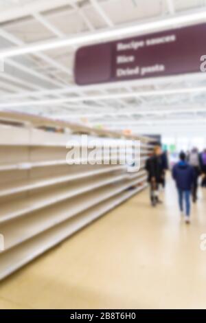 Verschwommenes Innenhintergrundbild leerer Supermarktregale aufgrund von Covid-19, Coronavirus, induzierter Lagerhaltung Stockfoto