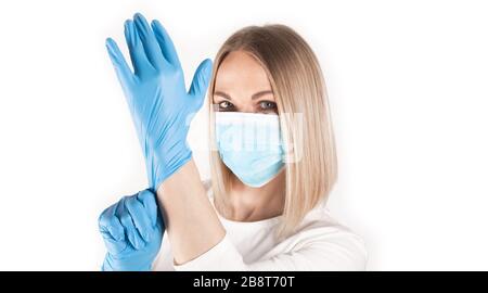 Frau legt medizinische Handschuhe nah an. Stockfoto