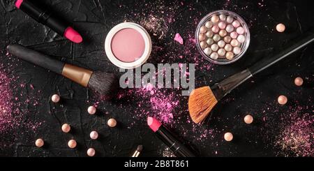 Professionelles Schminkpanorama auf schwarzem Hintergrund. Pinsel, Lippenstift und andere Produkte, ein flaches Lay mit einem Ort für Text Stockfoto