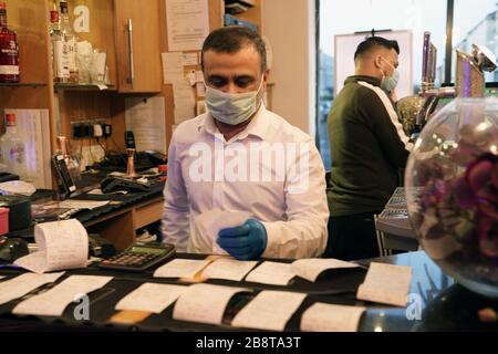 Die Mitarbeiter tragen Masken, wenn sie Bestellungen im Shikara Indian Restaurant in Whitley Bay, Tyne and Wear bearbeiten, wo sie das Restaurant geschlossen haben und im Rahmen der Reaktion Großbritanniens auf die Coronavirus Pandemie damit begannen, Mahlzeiten und Lieferungen zu nehmen. Stockfoto