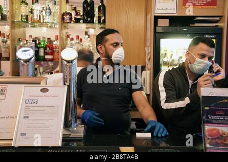 Die Mitarbeiter tragen Masken, wenn sie Bestellungen im Shikara Indian Restaurant in Whitley Bay, Tyne and Wear bearbeiten, wo sie das Restaurant geschlossen haben, um Kunden abzusetzen und im Rahmen der Reaktion Großbritanniens auf die Coronavirus Pandemie mit dem Mitnehmen von Mahlzeiten und Lieferungen zu beginnen. Stockfoto