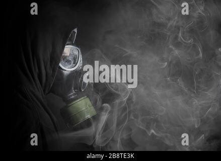 Mann in einer Gasmaske im Rauch, schwarz Stockfoto