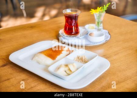 Türkische Traditionelle Wüste Kazandibi. Traditioneller Türkischer Tee. Banane und Haselnusskörner in Scheiben geschnitten. Milchpudding Stockfoto