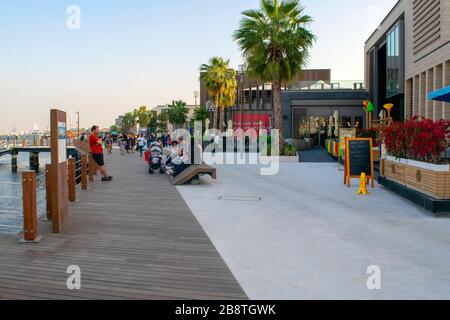 Dubai/VAE - 21. Februar 2020: Al Seef neuer moderner Bereich am Bur Dubai mit Restaurants, Cafés und Yachthafen mit voll bedrängten Yachten. Holzpromenade in Duba Stockfoto