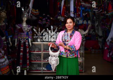 (200323) -- RONGSHUI, 23. März 2020 (Xinhua) -- Huang Yuping zeigt Miao Silberschmuck im Autonomen Kreis Rongshui Miao, südchinesische Autonome Region Guangxi Zhuang, 13. März 2020. 2012 ging Huang Yuping nach Rongshui County, um Miao Kostümwerkstatt einzurichten und armen Frauen zu helfen, zu Hause zu arbeiten. Der Autonome Kreis Rongshui Miao ist ein tief verarmter Kreis in Guangxi und ein wichtiger Kreis in den nationalen Armutsbekämpfungs- und Entwicklungsarbeiten. Es ist auch ein großer Exportbezirk für Arbeitskräfte. Die Arbeit im Freien ist für viele arme Familien der Hauptansatz, ihr Einkommen zu erhöhen. In den letzten Jahren Stockfoto