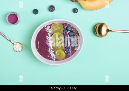 Die mit Samen, Blumen und Brombeeren bestockte Smoothie-Schüssel aus Akai-Beeren Stockfoto