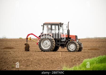 Traktor gräbt Löcher für Baumbepflanzung - Kopierraum Stockfoto