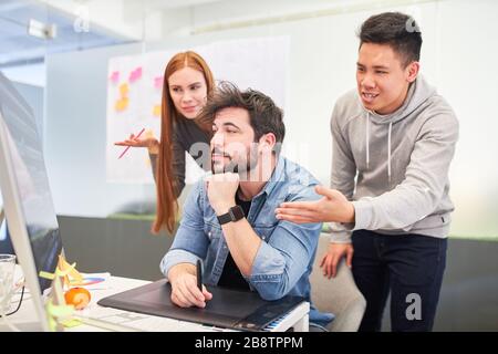 Webdesigner und Grafikdesigner auf dem Computer diskutieren über eine kreative Lösung Stockfoto