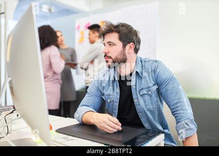 Grafikdesigner konzentriert sich auf ein Designprojekt mit Stift und Tablett Stockfoto