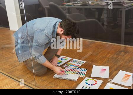 Grafikdesigner überprüft Farbmuster für den Druck in einer Designagentur Stockfoto