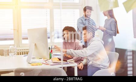 Das Start-Up-Team arbeitet im Büro am Computer zusammen Stockfoto