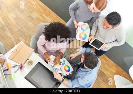 Grafik-Designer-Team in der Internet-Agentur diskutiert Farbgestaltung einer Website Stockfoto