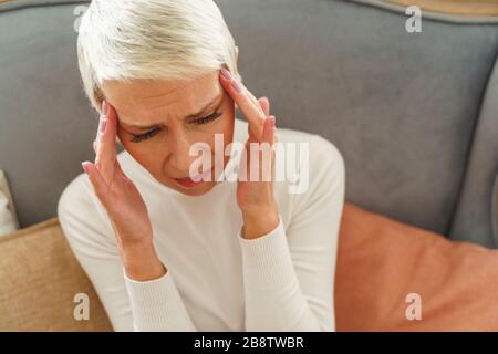 Depressive Frau mit den Händen an den Tempeln Stockfoto