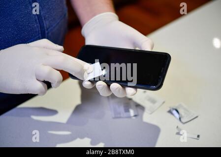 Gesundheit professionelles Reinigungs- und Sterilisationshandy mit weißen Latexhandschuhen aus Coronavirus COVID-19 Stockfoto