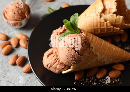 Eis, Waffeln und Mandel auf grauem Tisch, Nahaufnahme Stockfoto