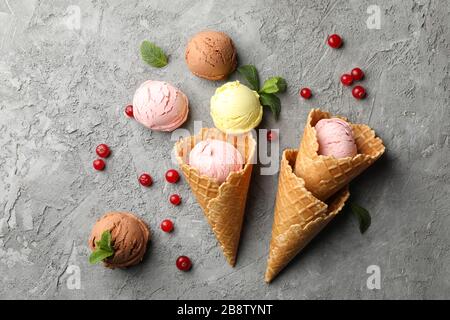 Eis mit Waffeln und Beeren auf grauem Hintergrund, Draufsicht Stockfoto