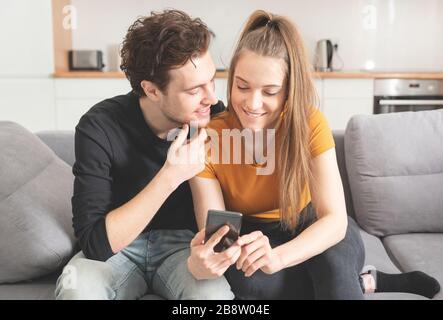 Verbinden Sie das Gerät über das schnelle Internet zu Hause mit dem Smartphone. Frau und Mann verwenden soziale Medien. Stockfoto