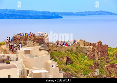 Santorini, Griechenland - 26. April 2019: Stadtpanorama von Oia mit bunten Häusern, Schloss und blauem Meer Stockfoto