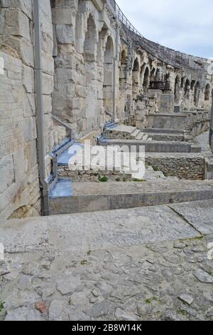 In einem alten römischen Amphitheater bei Nimes in Südfrankreich mit hohen Bogengängen, die zu den Sitzen führen. Eines der am besten erhaltenen Amphit Stockfoto