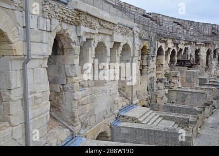 In einem alten römischen Amphitheater bei Nimes in Südfrankreich mit hohen Bogengängen, die zu den Sitzen führen. Eines der am besten erhaltenen Amphit Stockfoto