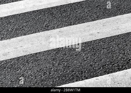 Zebramuster. Fußgänger streifende Straßenmarkierung, weiße Streifen über dunklem Asphaltpflaster, Hintergrundfoto Stockfoto