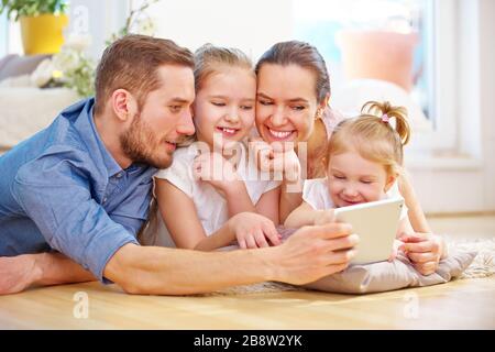 Glückliche Familie und Kinder, die zu Hause Tablet-pc im Internet nutzen Stockfoto