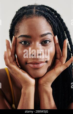 Gesicht einer schönen jungen schwarzen Frau mit Dreadlocks und Blick auf die Kamera Stockfoto
