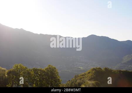 Die Landschaft eines Berges an einem sonnigen Tag mit einem Land an der Wand und vielen grünen Bäumen Stockfoto