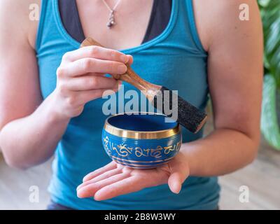 Haulerwijk - 07. märz 2020: Haulerwijk, Niederlande. Nahaufnahme der indischen Gesangsschüssel in der Hand der Frau. Meditations- und Entspannungskonzept Stockfoto