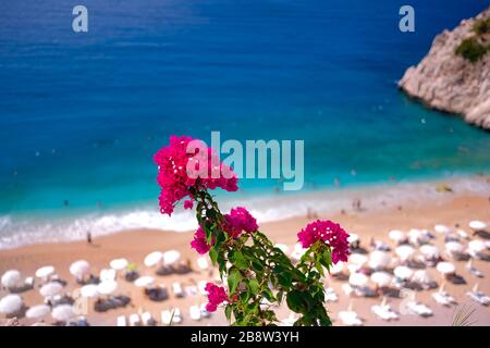 Paradiesischer Strand in Kas, Antalya - Türkei. Leerer Strand mit geschlossenen Sonnenschirmen am türkischen Strand Kaputaj Kemer Antalya. Stockfoto