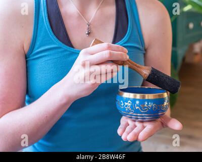 Haulerwijk - 07. märz 2020: Haulerwijk, Niederlande. Nahaufnahme der indischen Gesangsschüssel in der Hand der Frau. Meditations- und Entspannungskonzept Stockfoto