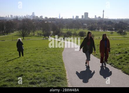 Die Skyline von London liegt in der Ferne hinter den Besuchern von Primsrose Hill, London. Stockfoto