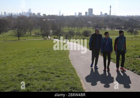 Die Skyline von London liegt in der Ferne hinter den Besuchern von Primsrose Hill, London. Stockfoto