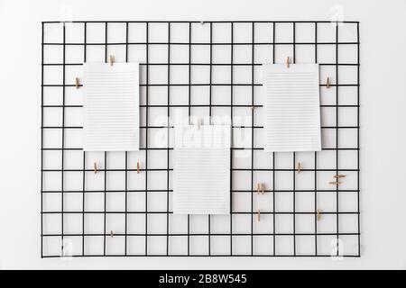Leeres Papier, das mit Haken im Raster als Hinweis, Erinnerung oder Plantafel für die erfolgreiche Ausführung von Aufgaben oder Zielen angebracht ist Stockfoto