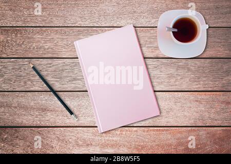 Bleistift und ein pinkfarbenes Notizbuch auf Holztisch. Vogelperspektive, Mock-up-Konzept Stockfoto
