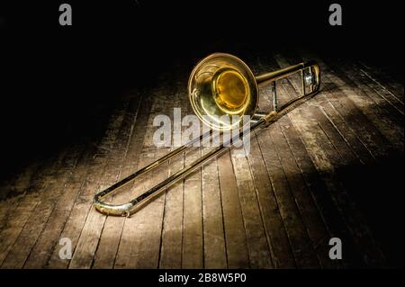 Wunderschönes goldenes Saxofon liegt auf einem Holzboden Stockfoto