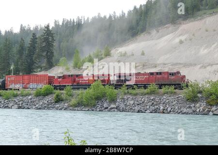 Revelstoke - 21. Mai 2019: Revelstoke, Britisch Kolumbien, Kanada. Güterzug, der sich entlang des Bow River in den kanadischen Rockies, Revelstoke, Britisch bewegt Stockfoto