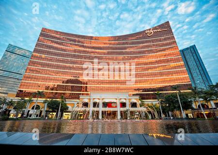 Der Himmel bei Sonnenuntergang spiegelt sich in der Hauptfassade des Wynn Macau wider, einem Luxushotel und Kasino. Macau, China. Stockfoto