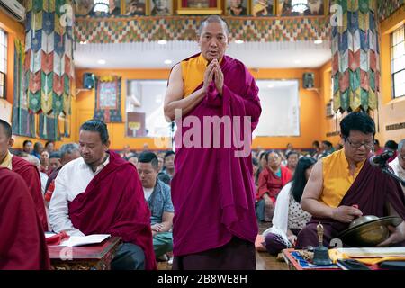 Eine nepalesische Mönch in traditionellen Gewändern rezitiert, Gebete & meditiert mit seiner gefalteten Händen an der Sherpa Kyidug Tempel in Elmhurst, Queens, New York City Stockfoto