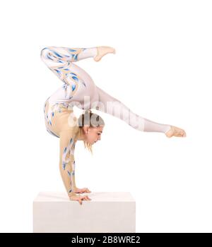 Akrobat Turnen, ein junger Zirkuskünstler in einem weißen und blauen Anzug, führt akrobatische Elemente aus. Studio, das ein isoliertes Bild auf weißem Hintergrund abschießt Stockfoto