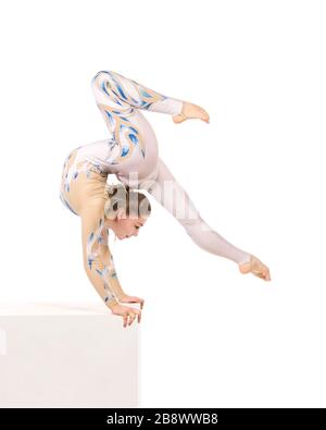 Akrobat Turnen, ein junger Zirkuskünstler in einem weißen und blauen Anzug, führt akrobatische Elemente aus. Studio, das ein isoliertes Bild auf weißem Hintergrund abschießt Stockfoto