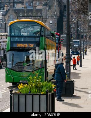 Edinburgh, Schottland, Großbritannien. März 2020. Leere Straßen während der Pandemie von Covid-19 Coronavirus in der Hauptstadt, da die Botschaft, zu Hause zu bleiben, die sozialen Distanzierungsmaßnahmen zu beachten scheint, trotz des schönen Sonnenscheins im Frühling Wirkung zu zeigen. Die Stadtbusunternehmen fahren weiterhin mit ihren Bussen und die Bustour-Verkäufer sind wegen des Mangels an Touristen und Kunden untätig Stockfoto