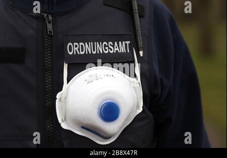 Magdeburg, Deutschland. März 2020. Ein Mitarbeiter der Stadtwache, eine Zusammenarbeit zwischen dem Ordnungsamt in Magdeburg und der Polizei, trägt auf seiner Weste eine Gesichtsmaske. Sachsen-Anhalt schickt mehr Polizei auf Patrouille, um zu überprüfen, ob die Regeln für die Eindämmung des neuartigen Corona-Virus (Covid-19) eingehalten werden. Kredit: Ronny Hartmann / dpa-Zentralbild / ZB / dpa / Alamy Live News Stockfoto
