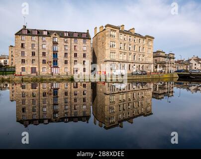 The Shore, Leith, Edinburgh, Schottland, Großbritannien. März 2020. Wetter in Großbritannien: Frühlingssonne und kleine Brise sorgen für perfekte Reflexionen der alten Gebäude im Wasser von Leith entlang des menschenleeren Flussufers, während die Menschen in sozialer Ferne wohnen Stockfoto